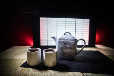 Çay konsepti. Japon çay töreni kültür doğu içecek. Bambu ve tradicional Japonya süs dekor elemanları ile masada çaydanlık ve bardak