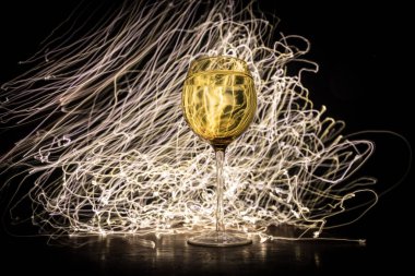 Ahşap masada şarap kadehi ve arka planda güzel renkli ışıklar. Karanlık arka planda şarap kadehleri. Seçici odaklanma. Kulüp içki konsepti