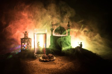 Su ve hurma. İftar akşam yemeğidir. Kum üzerinde Ramazan Kareem tatili dekorasyonu manzarası. Kutlama kartı, Müslüman bayramı davetiyesi. Seçici odak