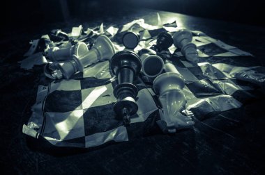 Satranç masası iş fikirleri ve rekabet konsepti. Kırık satranç tahtasıyla karanlık bir arka planda satranç figürü. Yaratıcı sanat dekorasyonu. Seçici odak