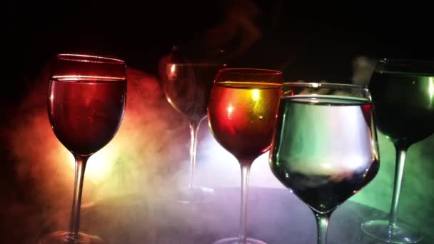 背景に美しいトーンのライトと木製のテーブルの上のワインのゴブレット 暗い背景にワインのグラス 選択的フォーカス クラブドリンクのコンセプト — ストック動画
