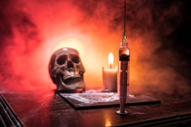 Narkotik uyuşturucu sorunu kavramı. Uyuşturucu şırıngası ve narkotik özellikler ahşap masada. Satın alma, uyuşturucu bulundurma ve satışı yasalar tarafından cezalandırılır. Yaratıcı sanat dekorasyonu