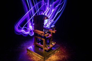 Karanlıkta idam cezası elektrikli sandalye minyatürü. Yaratıcı sanat dekorasyonu. Koyu bir sırt çantasındaki elektrikli sandalye modeli görüntüsü