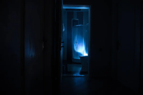 ハロウィンのコンセプト シャワーキャビンの人のホラーシルエット 光る照明でバスルームの中で狂人を殺す 長時間露光 — ストック写真