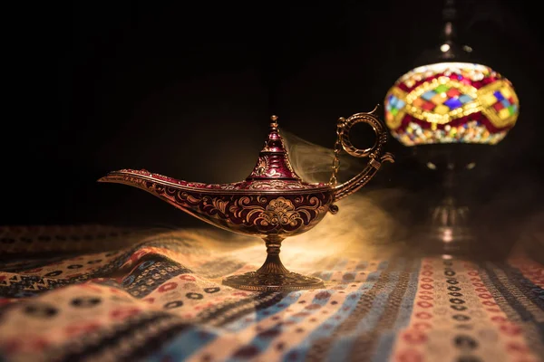 Antique Aladdin arabian nights genie style oil lamp with soft light white smoke, Dark background. Lamp of wishes concept