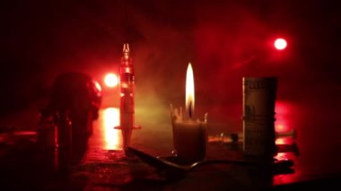 Narcotic drug problem concept. Silhouette of a man standing in the middle of the road on a misty night with giant Drug syringe and narcotic attributes. Creative artwork decoration