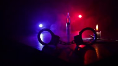 Narcotic drug problem concept. Silhouette of a man standing in the middle of the road on a misty night with giant Drug syringe and narcotic attributes. Creative artwork decoration