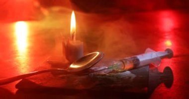 Narcotic drug problem concept. Silhouette of a man standing in the middle of the road on a misty night with giant Drug syringe and narcotic attributes. Creative artwork decoration