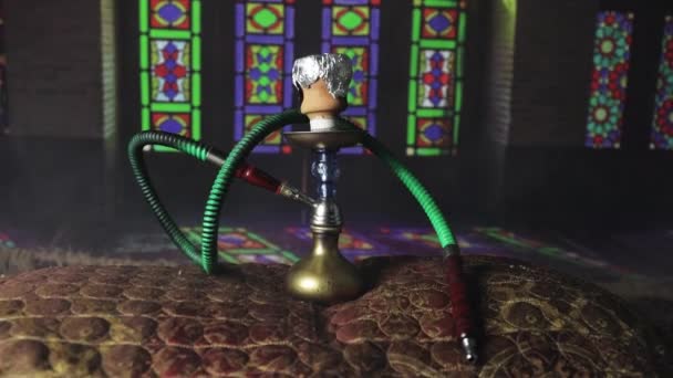 アラビア語のインテリアで蒸気の雲を作るShishaボウルにフカホット石炭 カーペットの上の東洋の装飾 バックライト付きのダークでスタイリッシュな東洋の社 — ストック動画