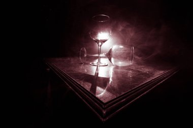 Boş şarap kadehini ahşap masaya koy ve arka planda güzel renkte ışıklar olsun. Karanlık arka planda şarap kadehleri. Seçici odaklanma. Kulüp içki konsepti