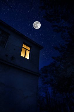 Geceleri ormanda Ay ve yıldızlarla dolu güzel bir manzara. Geceleri hayaletle terk edilmiş korkunç bir ev. Soğuk sonbahar gecesi