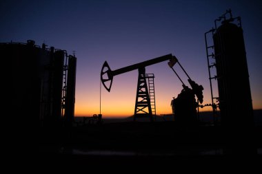 Petrol pompası ve petrol arıtma fabrikası gün batımında. Enerji endüstrisi konsepti. Seçici odaklanma. Yaratıcı sanat dekorasyonu.
