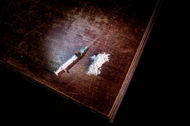 Narkotik uyuşturucu sorunu kavramı. Uyuşturucu şırıngası ve narkotik özellikler ahşap masada. Satın alma, uyuşturucu bulundurma ve satışı yasalar tarafından cezalandırılır. Yaratıcı sanat dekorasyonu