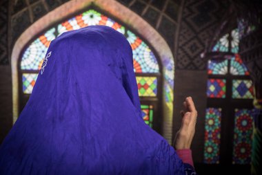 Müslüman bir kadın camide Allah için dua ediyor. Halıda dua eden Müslüman kadının elleri geleneksel kıyafetlerle, tesettürlü kadının elleri..