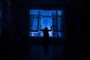 Odanın penceresinde duran bir adamın silüeti. Karanlık ruh hali kavramsal görüntü