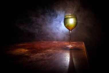 Ahşap masada şarap kadehi ve arka planda güzel renkli ışıklar. Karanlık arka planda şarap kadehleri. Seçici odaklanma. Kulüp içki konsepti