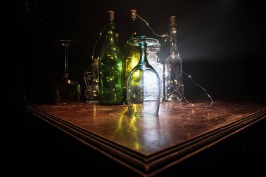 Ahşap masada şarap kadehi ve arka planda güzel renkli ışıklar. Karanlık arka planda şarap kadehleri. Seçici odaklanma. Kulüp içki konsepti