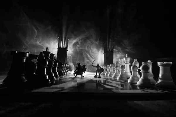 Medieval battle scene with cavalry and infantry on chessboard. Chess board game concept of business ideas and competition and strategy ideas Chess figures on a dark background with smoke and fog.