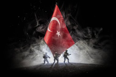 Türk ordusu konsepti. Türk bayrağına karşı silahlı askerlerin silueti. Yaratıcı sanat dekorasyonu. Askeri siluetler dövüş sahnesinde sisli bir arka planda. Seçici odak