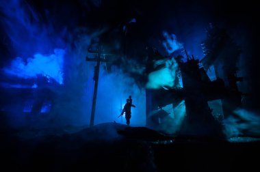 İmha edilmiş şehirde küçük bir çocuğu taşıyan bir kurtarıcı. Savaş konseptinin berbat yüzü. Işık ve sisli yaratıcı sanat masası dekorasyonu. Seçici odak.