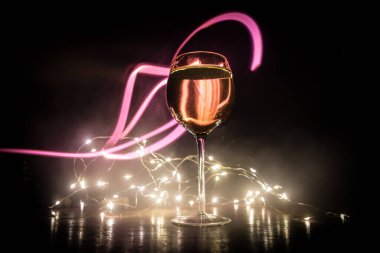 Ahşap masada şarap kadehi ve arka planda güzel renkli ışıklar. Karanlık arka planda şarap kadehleri. Seçici odaklanma. Kulüp içki konsepti