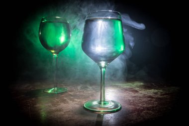 Ahşap masada şarap kadehi ve arka planda güzel renkli ışıklar. Karanlık arka planda şarap kadehleri. Seçici odaklanma. Kulüp içki konsepti