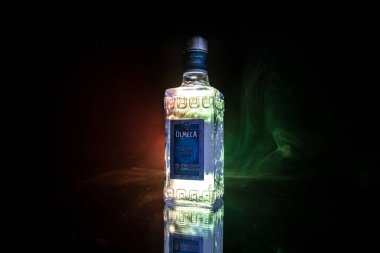 Bakü, Azerbaycan - 16 Haziran. 2019. Koyu tonda sisli arka plan üzerinde ahşap masa üzerinde Olmeca Tekila. Olmeca Tekila, Meksika'nın Jalisco kentinde üretilen bir tekiladır. Olmeca, Pernod Ricard Grubu'na ait..