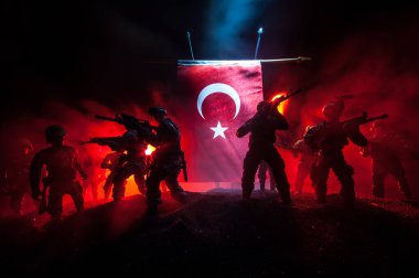 Türk ordusu konsepti. Türk bayrağına karşı silahlı askerlerin silueti. Yaratıcı sanat dekorasyonu. Askeri siluetler dövüş sahnesinde sisli bir arka planda. Seçici odak