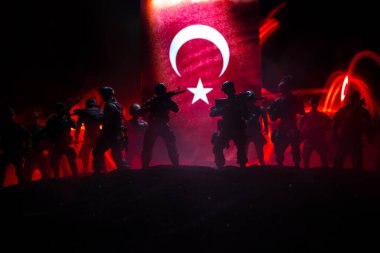 Türk ordusu konsepti. Türk bayrağına karşı silahlı askerlerin silueti. Yaratıcı sanat dekorasyonu. Askeri siluetler dövüş sahnesinde sisli bir arka planda. Seçici odak