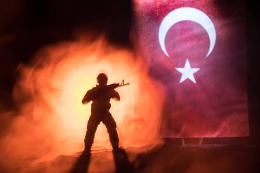 Türk ordusu konsepti. Türk bayrağına karşı silahlı asker silueti. Yaratıcı sanat dekorasyonu. Askeri siluetler dövüş sahnesinde sisli bir arka planda. Seçici odak
