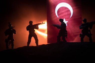Türk ordusu konsepti. Türk bayrağına karşı silahlı askerlerin silueti. Yaratıcı sanat dekorasyonu. Askeri siluetler dövüş sahnesinde sisli bir arka planda. Seçici odak