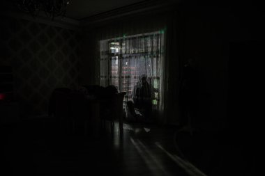 Odanın penceresinde duran bir adamın silüeti. Karanlık ruh hali kavramsal görüntü
