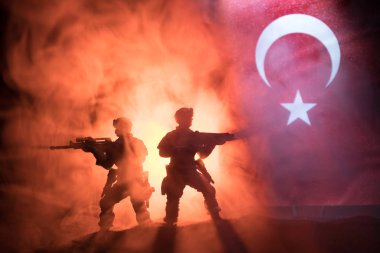 Türk ordusu konsepti. Türk bayrağına karşı silahlı askerlerin silueti. Yaratıcı sanat dekorasyonu. Askeri siluetler dövüş sahnesinde sisli bir arka planda. Seçici odak
