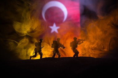 Türk ordusu konsepti. Türk bayrağına karşı silahlı askerlerin silueti. Yaratıcı sanat dekorasyonu. Askeri siluetler dövüş sahnesinde sisli bir arka planda. Seçici odak