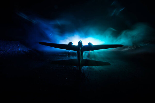 German Junker (Ju-88) night bomber at night. Artwork decoration with scale model of jet-propelled plane in possession. Toned foggy background with light. War scene. Selective focus