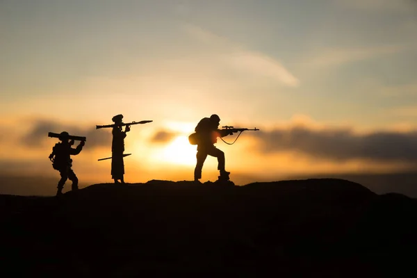 Military soldiers silhouettes with bazooka and rpg. War Concept. Military silhouettes fighting scene on war fog sky background, Mojahed with rpg and us soldier with bazooka at sunset. Attack scene