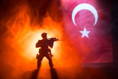 Türk ordusu konsepti. Türk bayrağına karşı silahlı asker silueti. Yaratıcı sanat dekorasyonu. Askeri siluetler dövüş sahnesinde sisli bir arka planda. Seçici odak