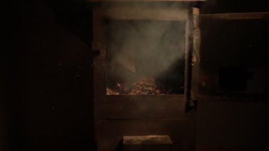 Küçük siyah demir sobada ateş yanıyor. Geleneksel Azerbaycan fındık sobası yakın çekim görüntüleri