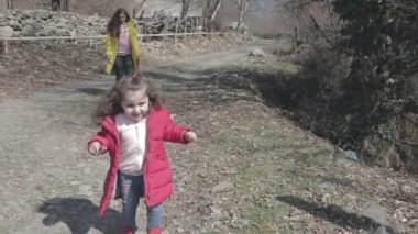 Kadın kızıyla birlikte doğada vakit geçiriyor.