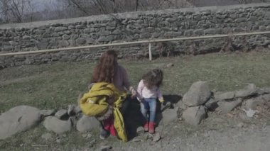 Kadın kızıyla birlikte doğada vakit geçiriyor.