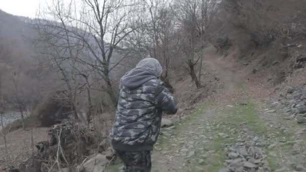 戴面具的男子拿着冲锋枪准备在森林里进攻 危险的强盗瞄准枪 在山路军事行动期间的特别士兵 — 图库视频影像
