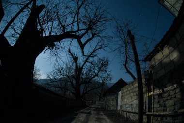 Gece sessiz köyde dolunay var. Ay ışığı altındaki dağ köyünün güzel gece manzarası. Azerbaycan doğası. Uzun pozlu çekim