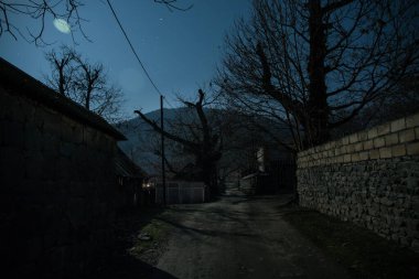 Gece sessiz köyde dolunay var. Ay ışığı altındaki dağ köyünün güzel gece manzarası. Azerbaycan doğası. Uzun pozlu çekim
