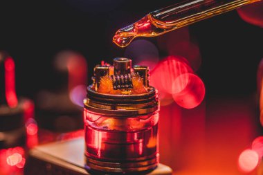 Vape kavramı. Elektronik sigara vape patlama. Duman bulutları ve vape sıvı şişe koyu arka plan üzerinde. Işık efektleri. Vape reklam olarak yararlı. Seçici odak