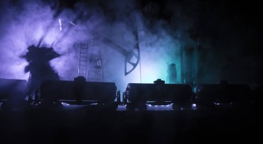 Petrol pompası ve petrol rafineri fabrikası geceleri sis ve arka planda. Enerji endüstrisi konsepti. Petrol tankı vagonlarıyla gece endüstriyel demiryolu. Seçici odaklanma. Sanat eseri dekorasyonu.
