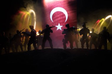 Türk ordusu konsepti. Türk bayrağına karşı silahlı askerlerin silueti. Yaratıcı sanat dekorasyonu. Askeri siluetler dövüş sahnesinde sisli bir arka planda. Seçici odak