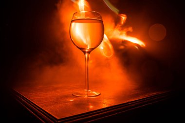 Ahşap masada şarap kadehi ve arka planda güzel renkli ışıklar. Karanlık arka planda şarap kadehleri. Seçici odaklanma. Kulüp içki konsepti