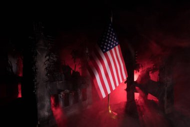 Yakın plan, Usa bayrağı yok edilmiş şehre karşı. Madalyalı diyorama. Savaş krizi kavramı ve uluslar arasındaki siyasi çatışmalar. Seçici odak