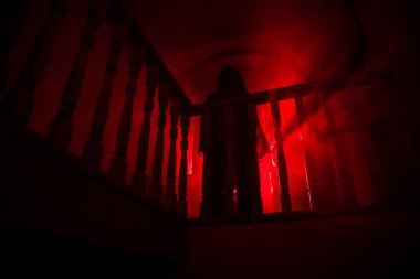 Terk edilmiş eski korkunç malikanenin içinde. Korku hayaleti silueti bodruma inen şatonun merdivenlerinde duruyor. Korku Cadılar Bayramı konsepti