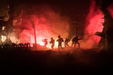 Savaş Konsepti. Askeri siluetler savaş sisli gökyüzü arka planında savaş sahnesi, Dünya Savaşı Askerleri Silueti Bulutlu Gökyüzünün Altında Gece. Harap olmuş şehirde savaş. Seçici odak